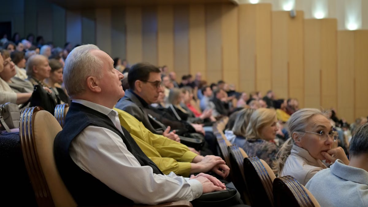A diverse audience attentively listening during a conference in an auditorium.